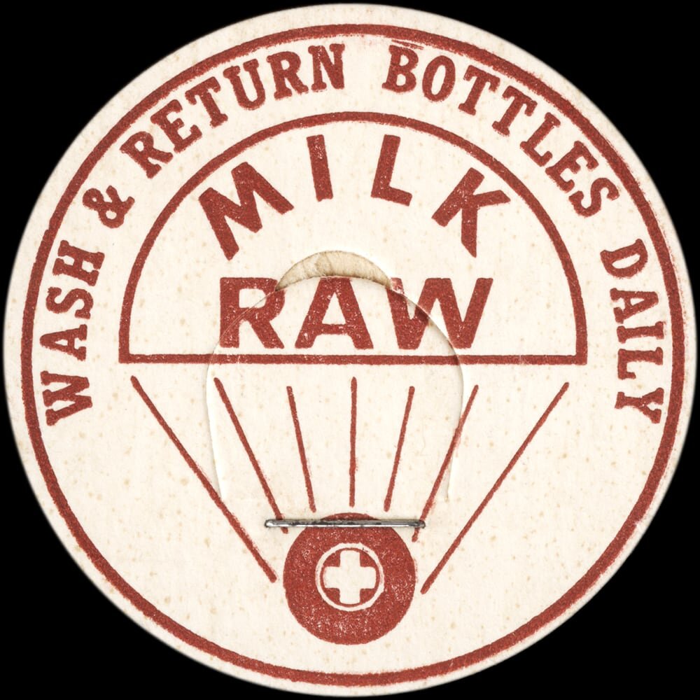 Vintage circular dairy cap with printed typographic milk advertising and a metal pull tab.