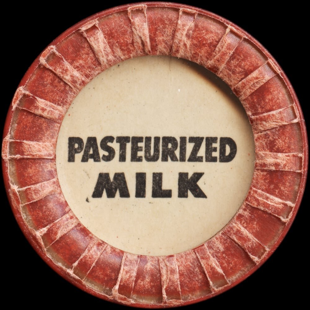 Vintage circular dairy cap with printed typographic milk advertising and a metal pull tab.