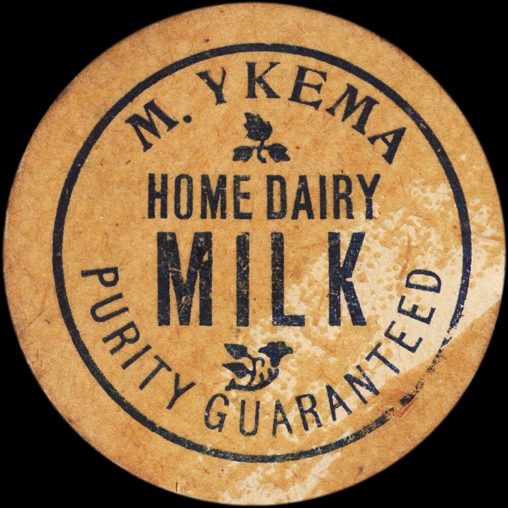 Vintage circular dairy cap with printed typographic milk advertising and a metal pull tab.