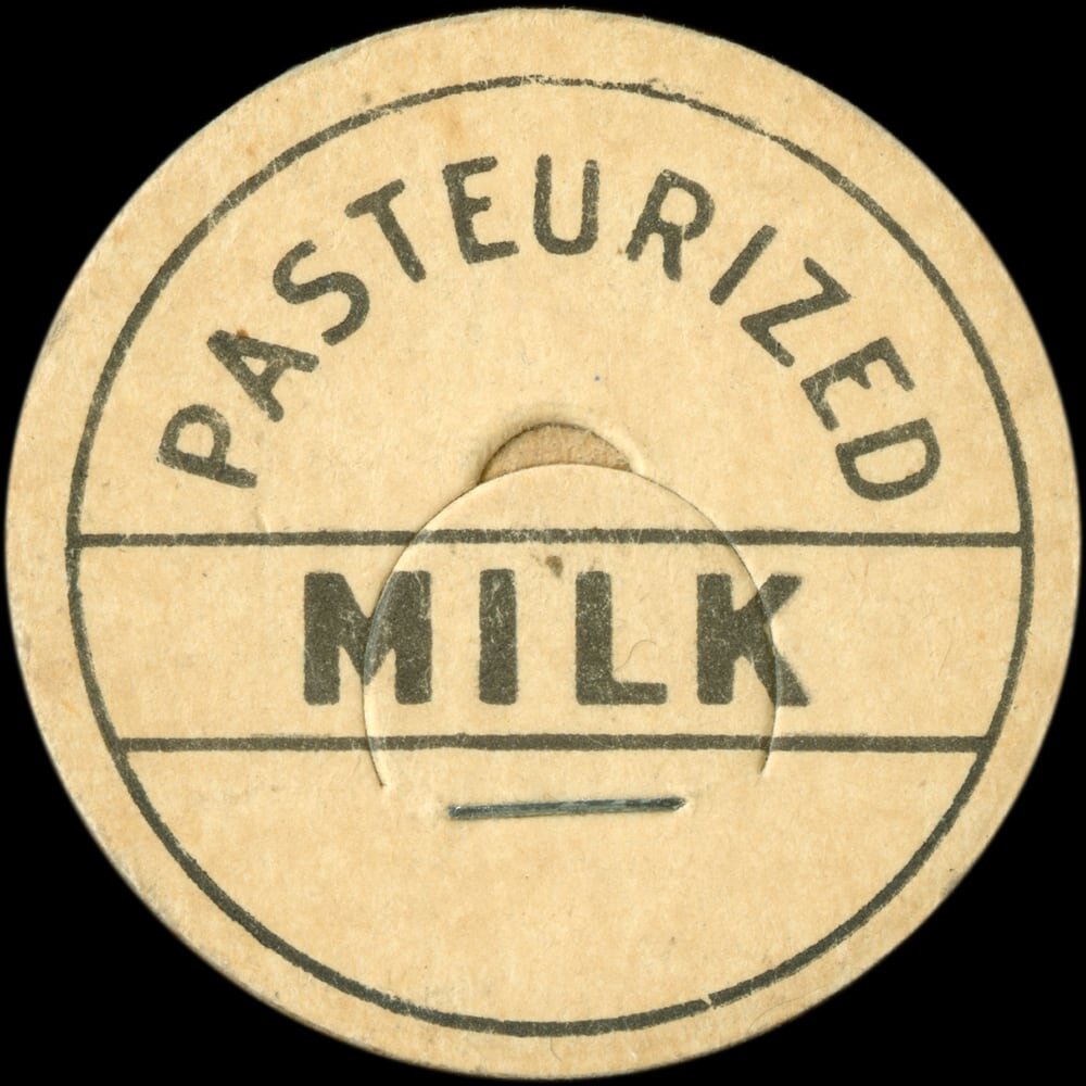 Vintage circular dairy cap with printed typographic milk advertising and a metal pull tab.