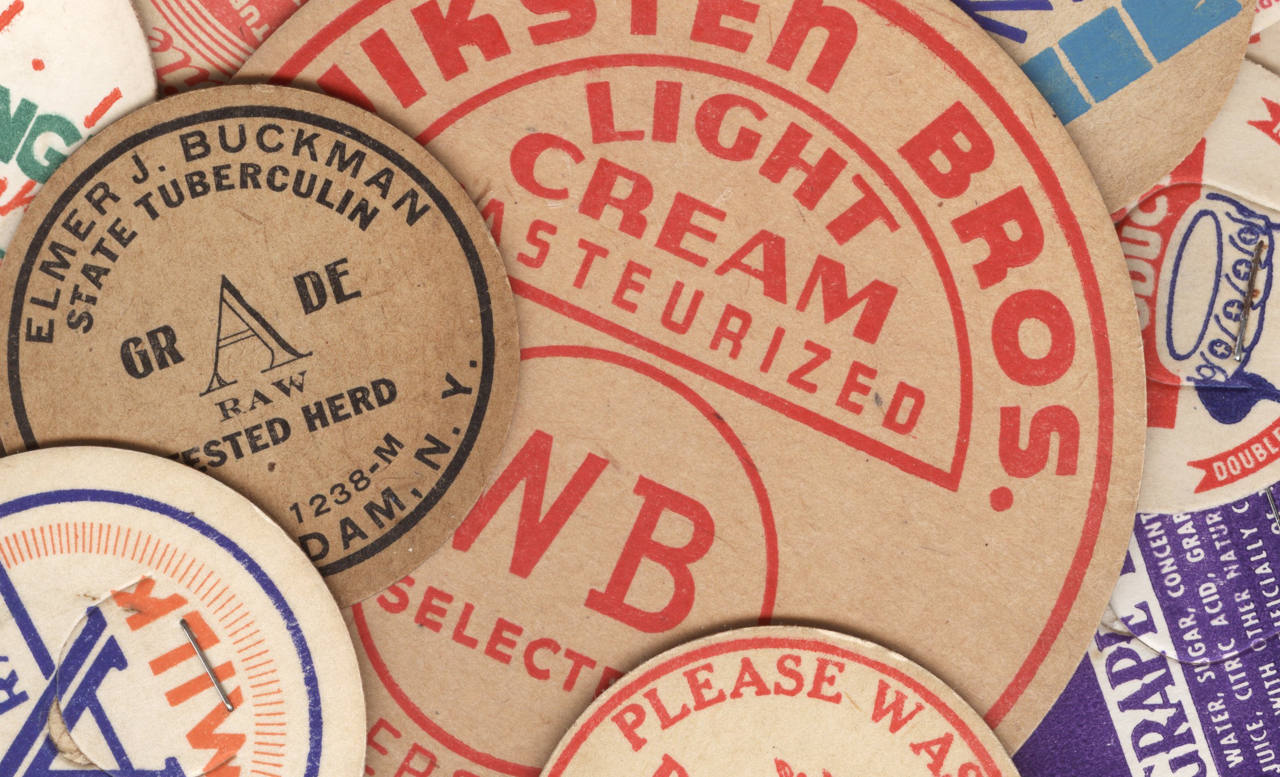 Vintage circular dairy cap with printed typographic milk advertising and a metal pull tab.