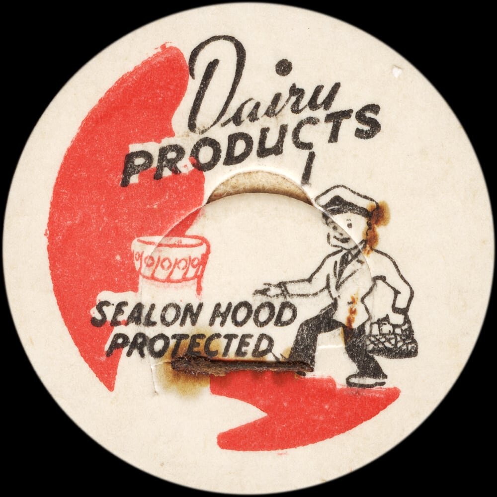 Vintage circular dairy cap with printed typographic milk advertising and a metal pull tab.