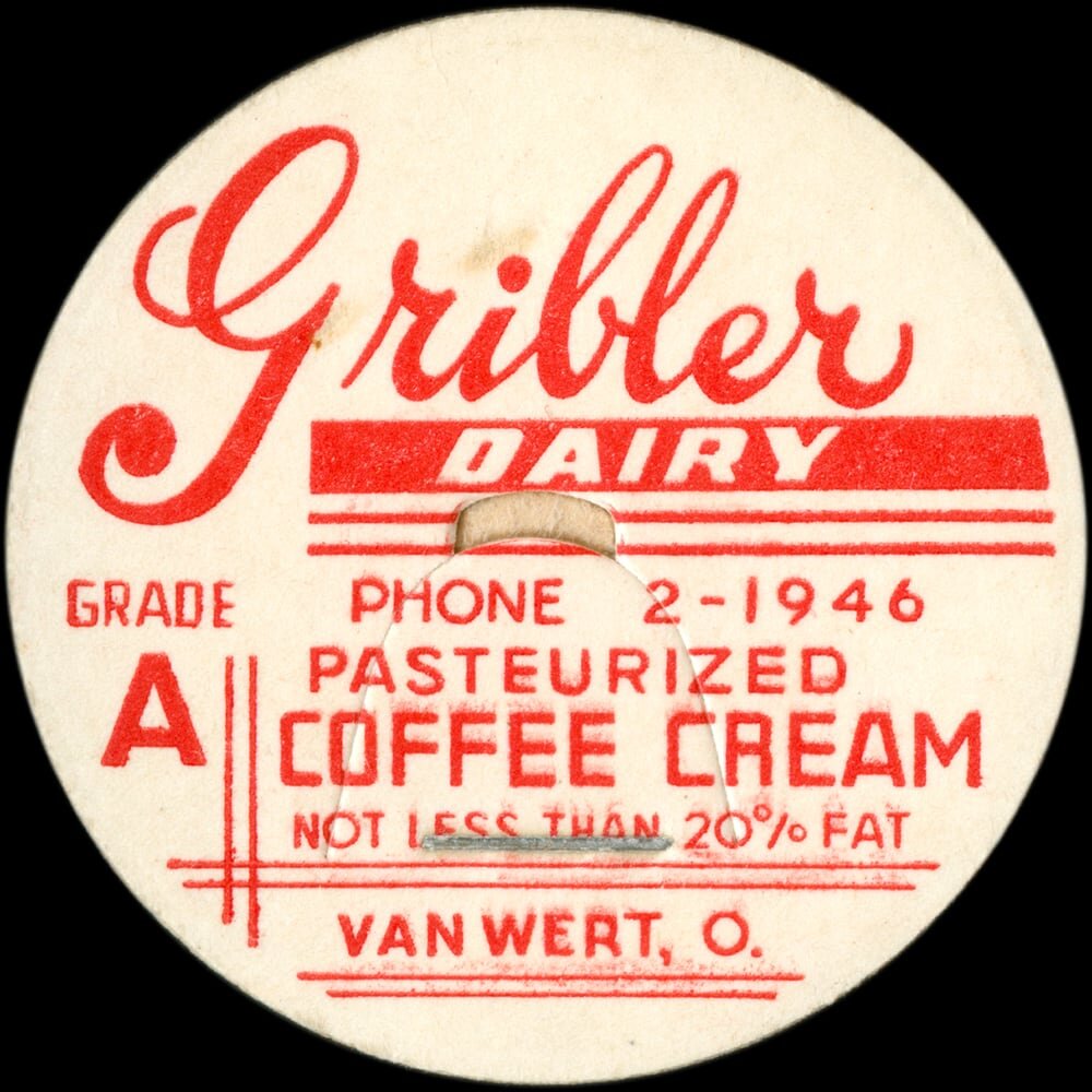 Vintage circular dairy cap with printed typographic milk advertising and a metal pull tab.