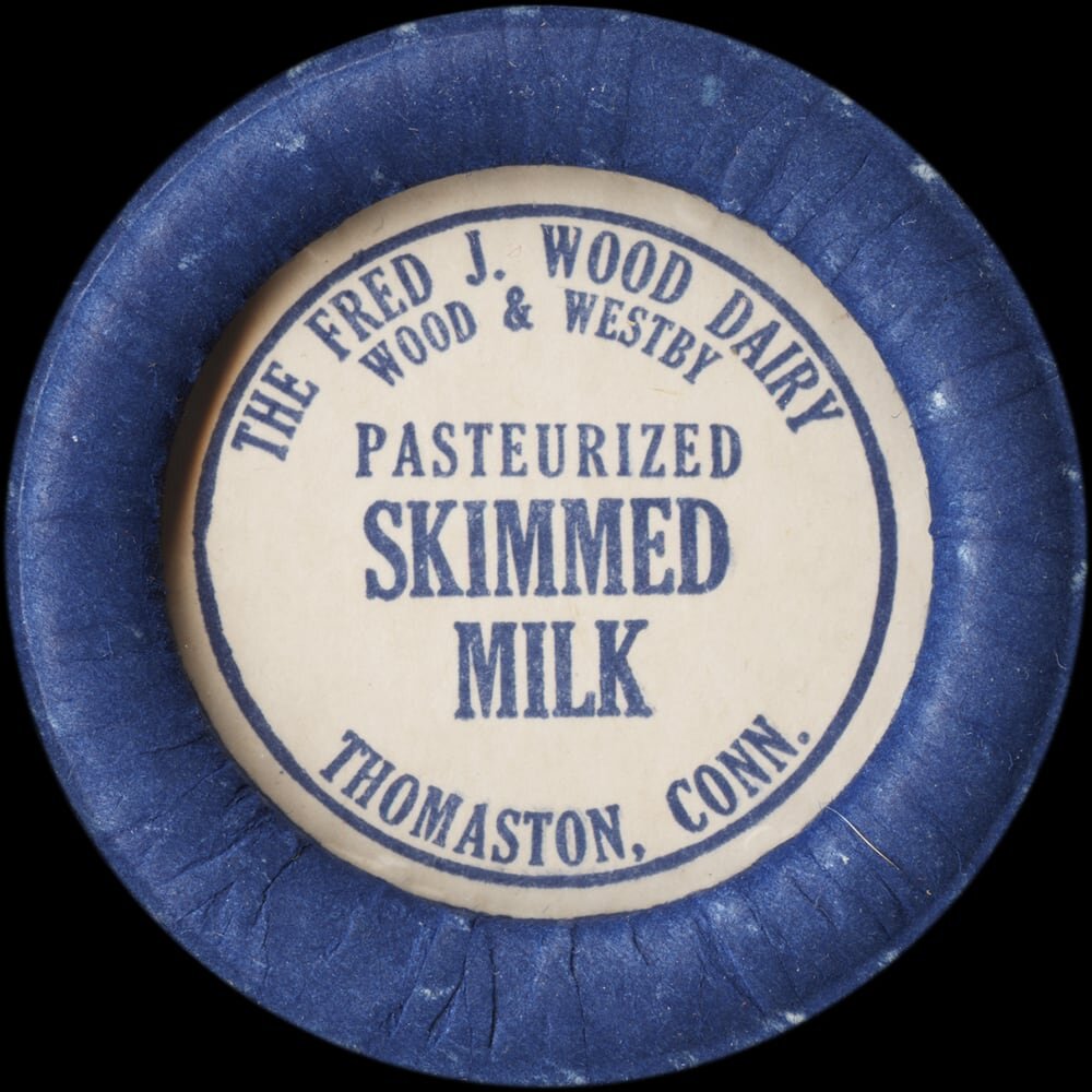 Vintage circular dairy cap with printed typographic milk advertising and a metal pull tab.