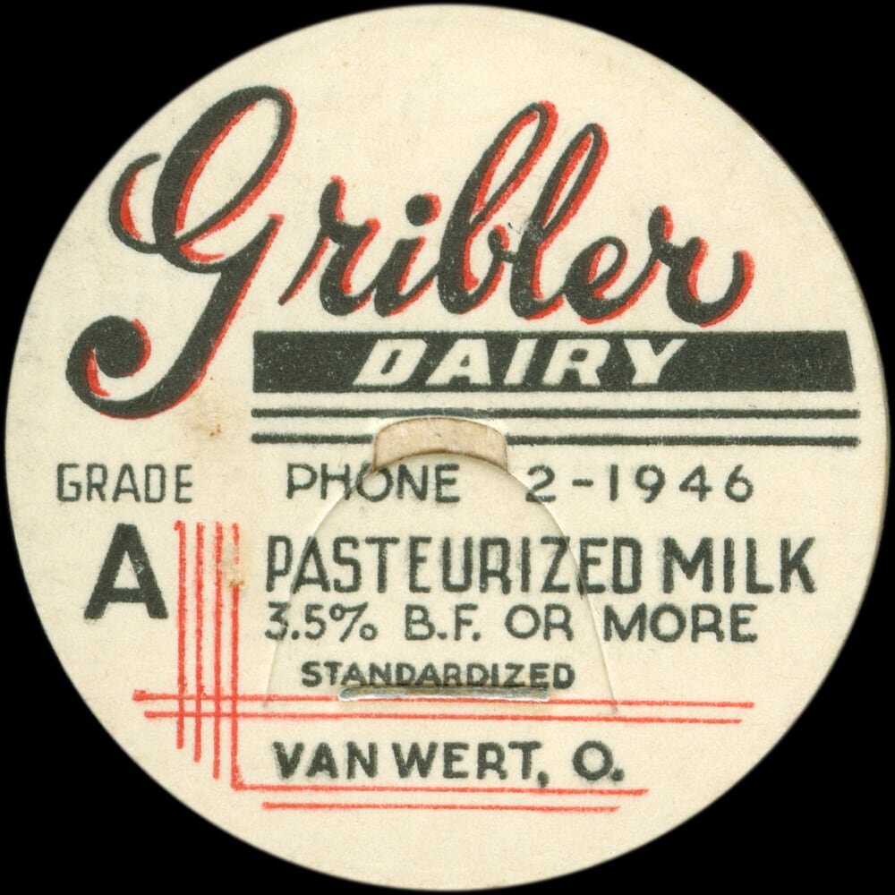 Vintage circular dairy cap with printed typographic milk advertising and a metal pull tab.